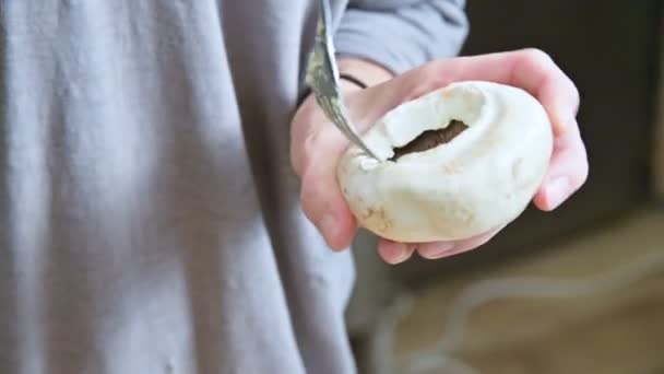 Primer plano de las manos femeninas de un cocinero en una cocina casera relleno de setas blancas con especias y mantequilla para hornear con un tenedor — Vídeos de Stock