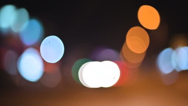 Bokeh χρωματιστά φώτα της πόλης το βράδυ. Μετακίνηση κύκλους των φώτων τροχαίας φώτα πινακίδες. Defocused νύχτα εμφαση σε δρόμο της πόλης — Αρχείο Βίντεο