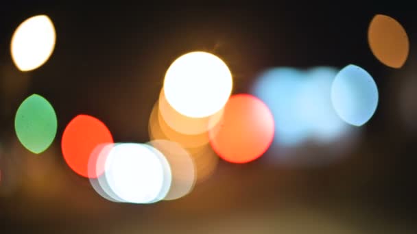 Luzes bokeh coloridas na cidade noturna. círculos móveis de semáforos sinais de luzes. Destaques noturnos desfocados na estrada da cidade — Vídeo de Stock