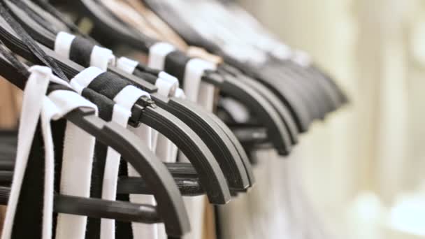 Close-up van multi-gekleurde T-shirts op hangers in een kledingwinkel — Stockvideo