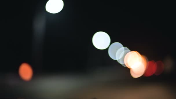 Farbige Bokeh-Lichter in der Nacht Landstraße. bewegliche Kreise von Ampeln. Defokussierte Nachtstraße — Stockvideo
