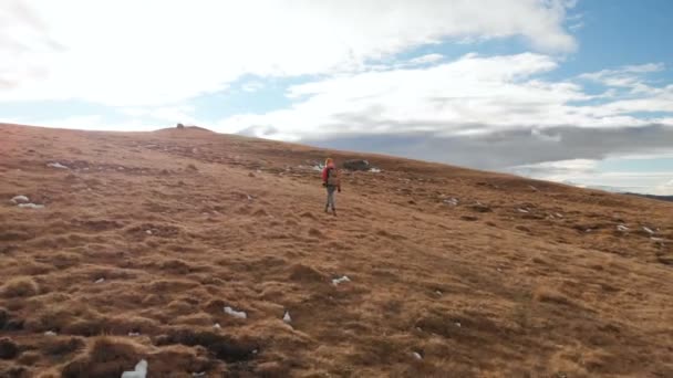 Hava görünümü. Kız Gezgin günbatımında karşı dağlar zemin sarı çim ile Yamaç ve bulutlu bir plato boyunca yürüyüş boynunda bir kamera ile — Stok video