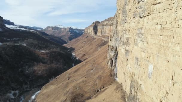 Flygfoto över rörelsen längs väggens rock Canyon i ravinen i Kaukasus. Mycket nära klippan i vinter när det är lite snö. 4k — Stockvideo