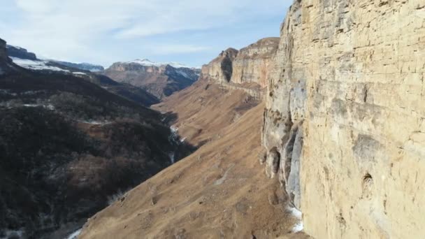 Veduta aerea del movimento lungo la parete rocciosa del canyon nella gola nel Caucaso. Molto vicino alla roccia in inverno quando c'è poca neve. 4k — Video Stock