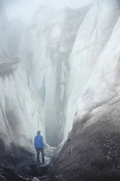Egy ingyenes mászó jég baltával áll a nagy gleccser mellett egy epikus kiváló a köd, a hegyek lábánál. Leküzdhetetlen akadály — Stock Fotó
