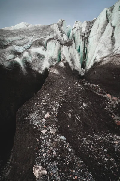 Close-up Crack es una grieta azul profunda que se encuentra en la capa de hielo y barro negro en el glaciar. Amplio ángulo y cielo dramático —  Fotos de Stock