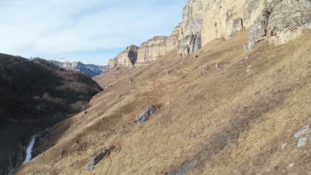 Veduta aerea del movimento lungo la parete rocciosa del canyon nella gola nel Caucaso. Molto vicino alla roccia in inverno quando c'è poca neve. 4k — Video Stock