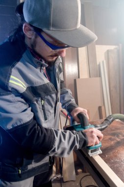 Elektrik düzlemin bir ev ahşap atölyesinde çalışan genç bir marangoz portresi. Bir iş fikri ve bir ağaç işleme başlangıç kavramı. Geniş açı