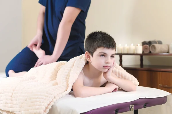 Paziente ragazzo alla reception di una massaggiatrice professionista. Terapia di massaggio ai piedi — Foto Stock