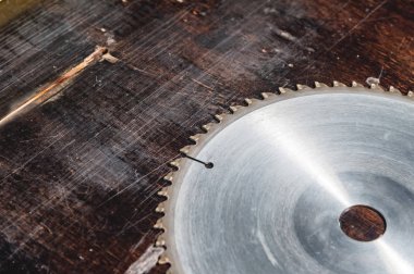 Yakın çekim yuvarlak ahşap masa Verscak arka plan üzerinde testere. Atölye, ahşap ürünlerin üretimi için. Aracı kesme jipler