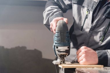 Yakın çekim home atölye bir işçi elinde elektrikli testere. Bir iş kurma. Usta