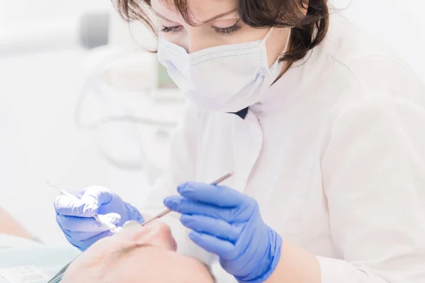 Ηλικίας άνδρα της ρεσεψιόν στον οδοντίατρο. Γυναίκα γιατρός εξετάζει το στόμα του ασθενή — Φωτογραφία Αρχείου