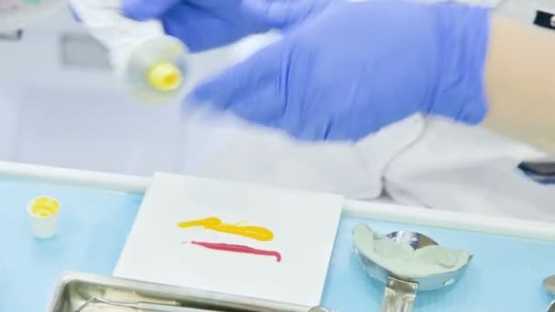 Gros plan sur la main des composants de mélange de dentisterie pour une préforme composite pour enlever la forme de la mâchoire et la morsure du patient — Video