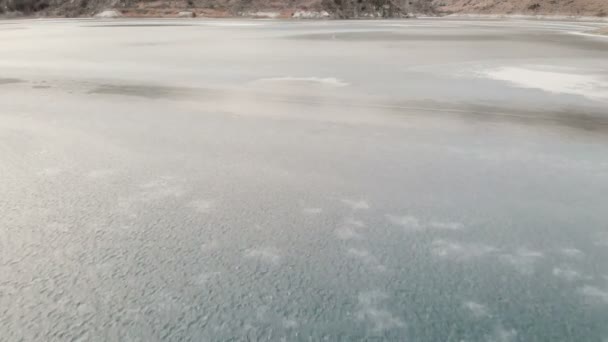 Vista aérea. Lago de montanha congelado no Cáucaso do Norte. A câmara está desligada. Crepúsculo nas montanhas — Vídeo de Stock