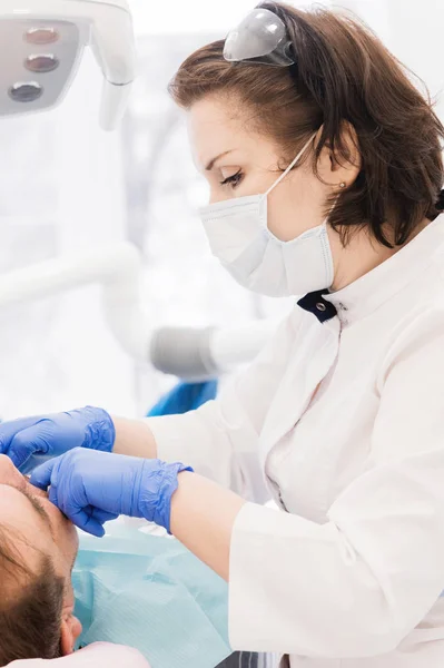 Homem envelhecido na recepção do dentista. Mulher médico examina os pacientes boca — Fotografia de Stock