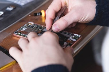 Demonte bir akıllı telefon tamir ev bir usta el Close-up. Kendini onarma elektronik evde kavramının