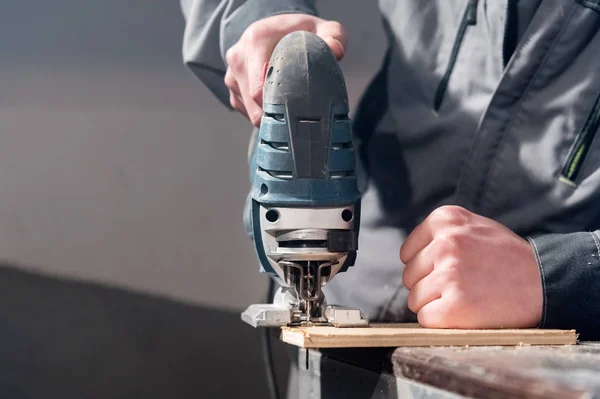 Close-up de carpinteiros mãos ferramentas elétricas de trabalho para o processamento de madeira. Poder Jigsaw — Fotografia de Stock