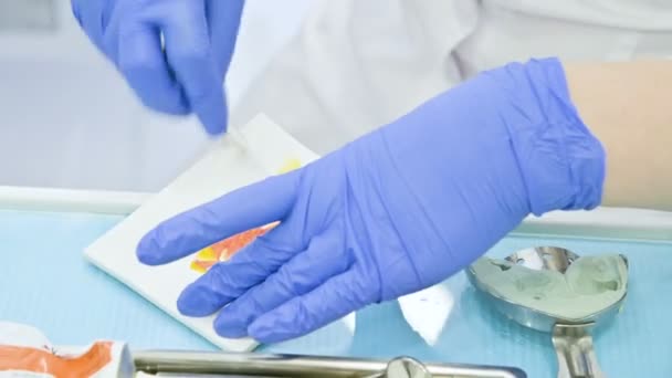 Zbliżenie dłoni stomatologii wymieszać składniki dla kompozytowych półprodukty do usuwania postaci od szczęki i ukąszenia przez pacjenta — Wideo stockowe