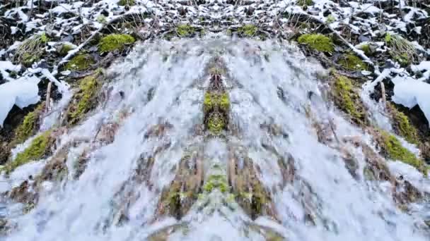 Movimento lento close-up do rio da montanha no inverno ao lado da neve e musgo verde. Kaleidoscope efeito reflexão psicodélica. Produção natural de água limpa — Vídeo de Stock