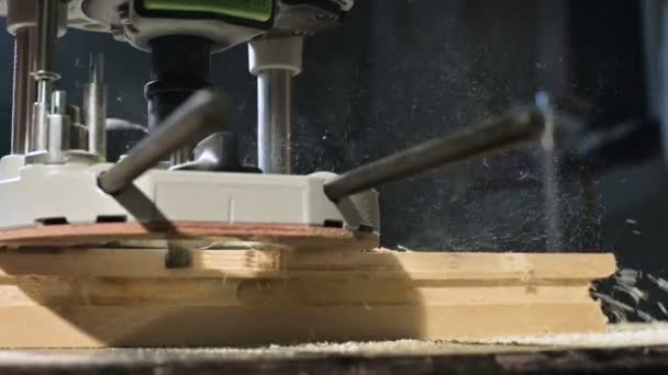 Primer plano de la mano de un carpintero que trabaja con un cortador eléctrico manual en un taller casero. Acabado de piezas de madera en cámara lenta — Vídeos de Stock