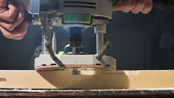 Közeli fel egy ácsok kéz dolgozó kézi elektromos vágó egy otthoni workshop. Fából készült alkatrészek lassú mozgásban — Stock videók