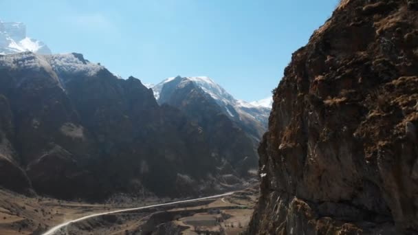 Le rovine di antiche torri su una roccia tra le montagne dell'Alta Balkaria. Veduta aerea della gola con una strada sterrata e un fiume di montagna nelle montagne del Caucaso. giornata di sole — Video Stock