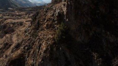 Üst Balkaria dağlarında bir kaya üzerinde antik yerleşim harabeleri. Çamur yolu ve Kafkaslar Dağları 'nda dağ kayaları ile vadiye hava görünümü. barış gündüz