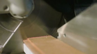 Dairesel testere ile bir makine üzerinde bir çalışmanın yakın çekim. Yavaş hareket halinde ahşap kütük dairesel makine kesme
