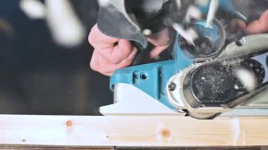 Bir ev atölyesinde bir elektrik uçağı ile çalışan bir marangozlar el yakın çekim. Yavaş hareket ahşap parçaları bitirme