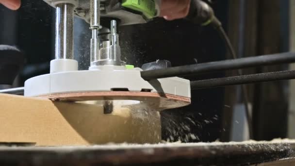 Primo piano di una falegnameria che lavora a mano con un taglierino elettrico manuale in un laboratorio domestico. Finitura parti in legno al rallentatore — Video Stock