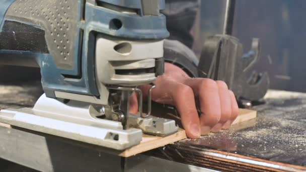 Maschio mani falegnami lavora come un puzzle elettrico nella sua officina di casa. Taglio parti in legno al rallentatore — Video Stock