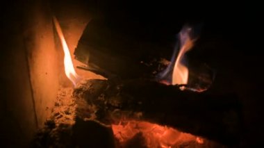 Gece refrakter cam arkasında modern bir ev soba kömürleri ile loş yanma odun yakın çekim. Düşük anahtar. Kamera tornalama ile yangına yakın hareket. Çevre dostu enerji