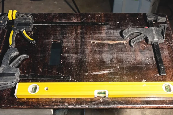 Desk joiner with plastic joinery clamps and waterpass level — Stock Photo, Image