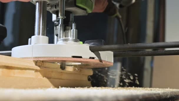 Primer plano de la mano de un carpintero que trabaja con un cortador eléctrico manual en un taller casero. Acabado de piezas de madera en cámara lenta — Vídeos de Stock