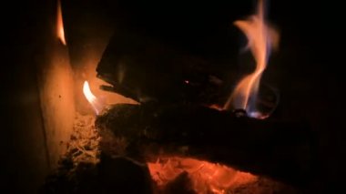 Gece refrakter cam arkasında modern bir ev soba kömürleri ile loş yanma odun yakın çekim. Düşük anahtar. Kamera tornalama ile yangına yakın hareket. Çevre dostu enerji