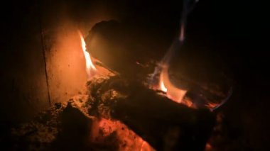 Gece refrakter cam arkasında modern bir ev soba kömürleri ile loş yanma odun yakın çekim. Düşük anahtar. Kamera tornalama ile yangına yakın hareket. Çevre dostu enerji