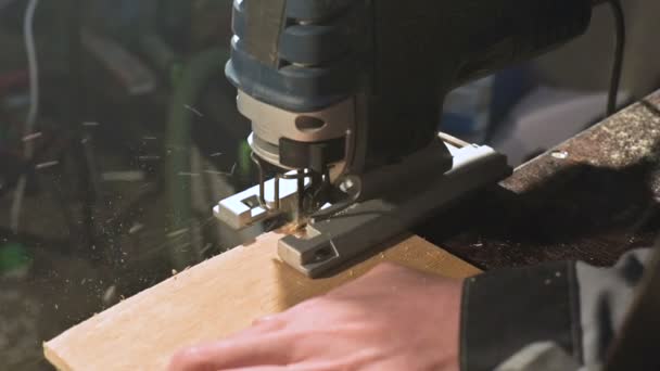 Férfi ácsok kezet működik, mint egy elektromos szúrófűrész otthonában műhely. Fából készült részek lassú mozgásban — Stock videók