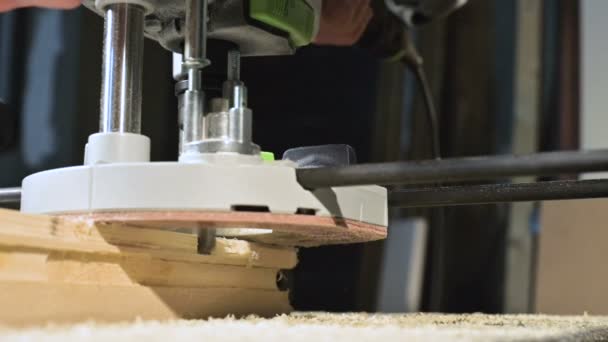 Großaufnahme. Ein Tischler schneidet mit einer elektrischen Frässäge ein Holzbrett. Zeitlupe von Staubpartikeln und Sägeblatt — Stockvideo