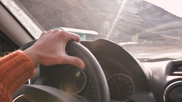 Primer plano de una mano femenina en un suéter naranja conduciendo un coche fuera de la ciudad. Mujer en cámara lenta conduciendo un coche — Vídeo de stock