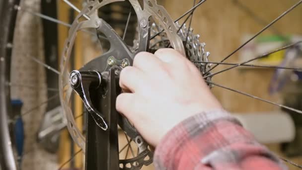 Närbild av en Masters hand demontering en böjd sticknål vid ett underhålls stativ för cykelhjul — Stockvideo