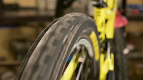ワークショップ修理機器におけるマウンテンスポーツバイクの回転ホイールのクローズアップ — ストック動画
