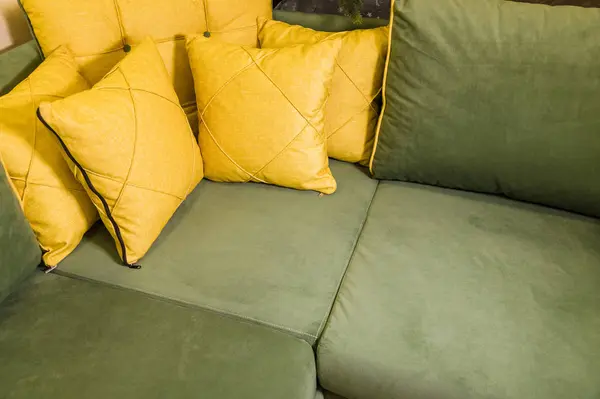Κοντινό-up πράσινο γωνιακό καναπέ με κίτρινα μαξιλάρια. Υφάσματα νέα έπιπλα μοντέρνο σχεδιασμό — Φωτογραφία Αρχείου