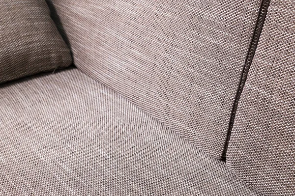 Elemento primo piano divano grigio-beige con cuscini scuri. Premium mobili nuovi — Foto Stock