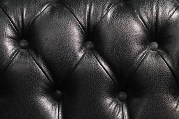 Primer plano de la parte posterior del sofá de cuero negro. Fondo Vintage de lujo — Foto de Stock