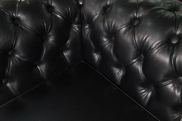 Esquina trasera de cerca de un sofá de cuero negro. Fondo Vintage de lujo — Foto de Stock