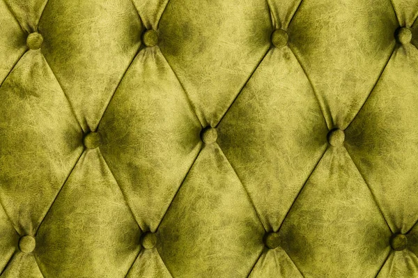 Kanepe yakın çekim velor kireç yüzeyi. Eğitim ekipmanları-velor paspaslar düğmeleri ile sıkılır. Sarı chesterfield tarzı kapitone döşeme arka plan