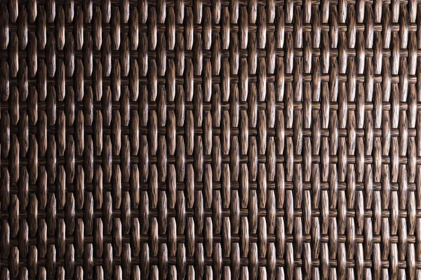 Tmavé hnědé pozadí je součástí proutěného nábytku z polymerních vláken. Syntetický luxusní substrát — Stock fotografie