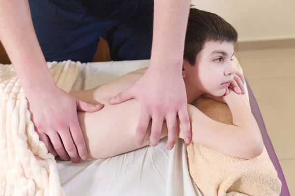 Zrelaksowany mały chłopiec na recepcji w kręgarza. Zabieg masażu Wellness — Zdjęcie stockowe