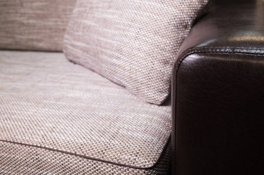 Siyah deri kolçak ile yakın çekim elemanı Bej gri kanepe. Minderli birinci sınıf mobilyalar