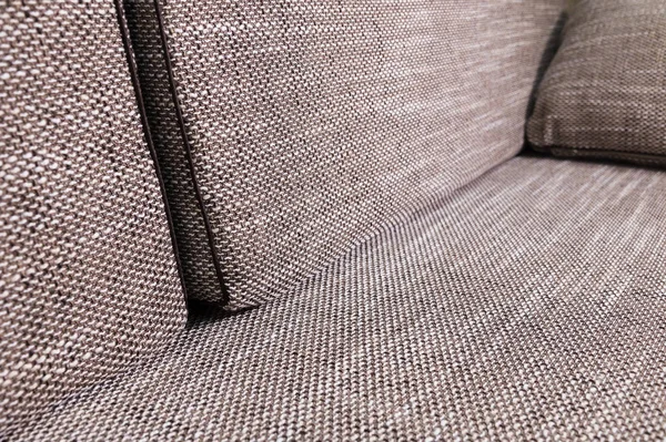 Elemento primo piano divano grigio-beige con cuscini scuri. Premium mobili nuovi — Foto Stock
